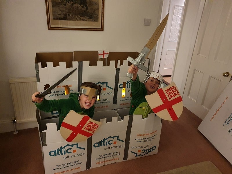 Children playing in a carboard fort
