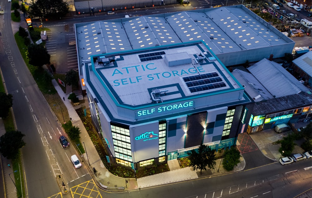 Aerial view of a large commercial building. Attic Self Storage signage is visible on the side.
