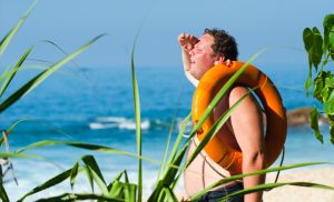 Man looking out for something on a beach