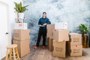 Man standing in a room filled with moving boxes