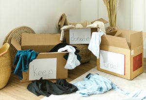 clothes segregated in keep, donate and trash boxes